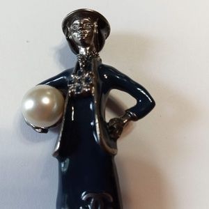 COCO holding pearl brooch